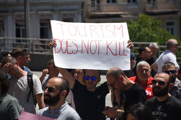 На плакате написано Туризм не убить. Акция проходила под лозунгом Спасем туризм - Sputnik Грузия