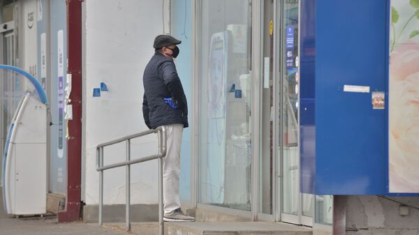 Мужчина в куртке и маске у аптеки - Sputnik Грузия