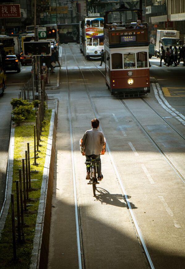 В пятерку вошел Гонконг. Вид на велосипедиста и трамваи в центре Гонконга - Sputnik Грузия