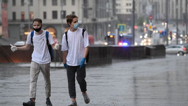 Молодые люди на одной из улиц в Москве во время дождя - Sputnik Грузия