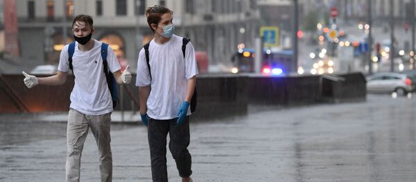 Молодые люди на одной из улиц в Москве во время дождя Молодые люди на одной из улиц в Москве во время дождя - Sputnik Грузия