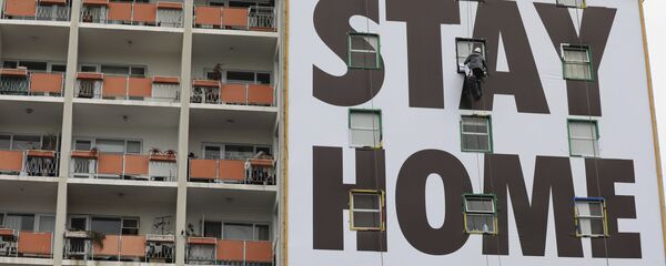Огромный баннер с призывом Оставайся дома, если можешь! на стене дома во время пандемии COVID 19 в Кейптауне, ЮАР - Sputnik Грузия