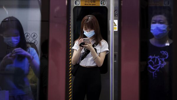 Молодая женщина в медицинской маске в метро во время пандемии коронавируса COVID 19 в Пекине Китай - Sputnik Грузия