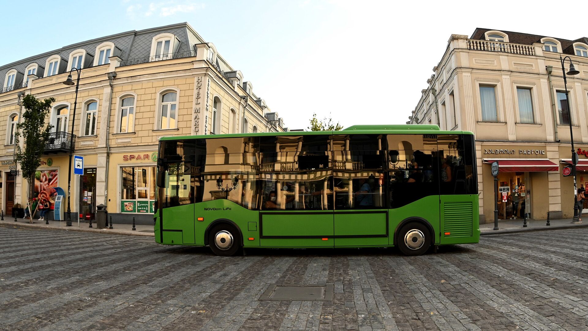 Зеленый пассажирский автобус едет по проспекту Агмашенебели - Sputnik Грузия, 1920, 25.04.2022