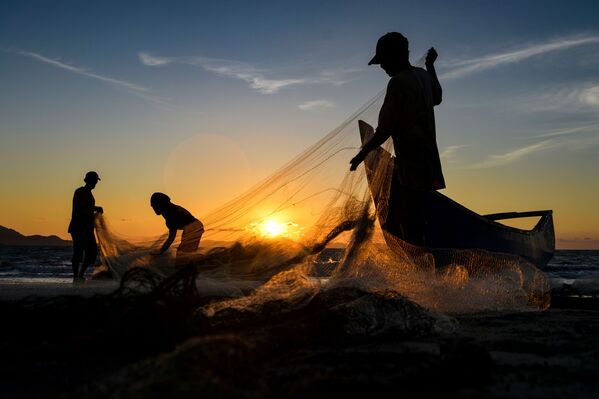 Рыбаки чистят сети после рыбалки на закате в Банда-Ачех, в Индонезии - Sputnik Грузия