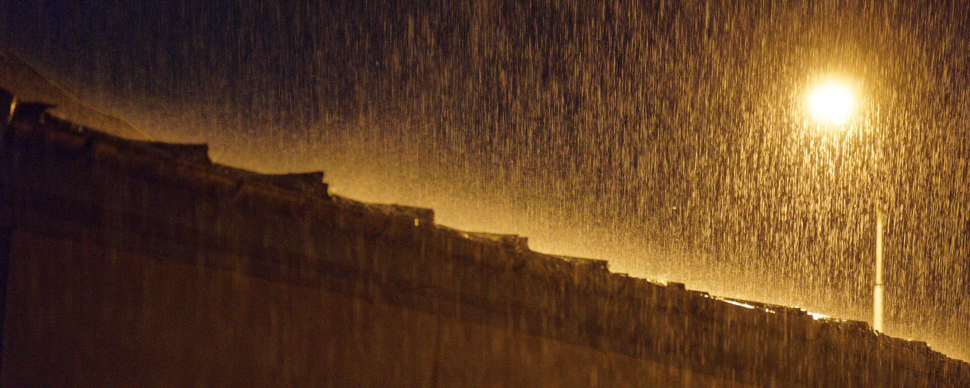 Сильный дождь. Струи воды в свете уличного фонаря - Sputnik Грузия, 1920, 04.07.2021