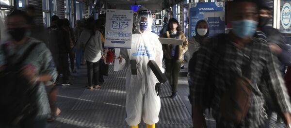 Сотрудник автобусной станции в защитном костюме во время пандемии коронавируса COVID 19 в Джакарте, Индонезия - Sputnik Грузия