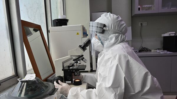 Ученый в лаборатории изучает под микроскопом частицы COVID-19 - Sputnik საქართველო