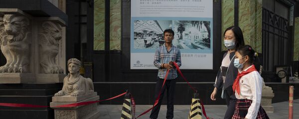 Мама с дочкой в масках во время пандемии коронавируса COVID 19 идут утром в школу в Пекине, Китай мимо оздоровительного клуба - Sputnik Грузия