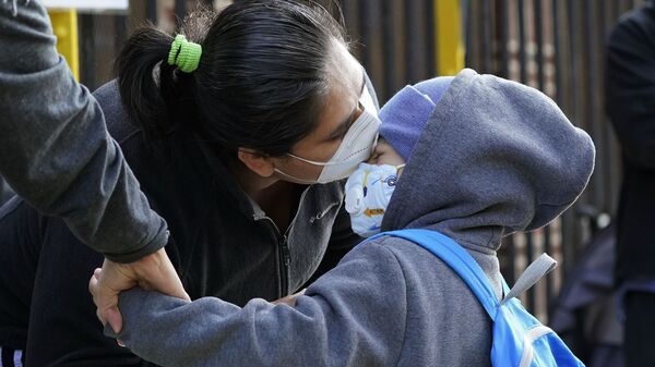Пандемия коронавируса COVID-19. Мама и дочь в масках целуются в районе Куинс, Нью-Йорк, США перед началом занятий в школе - Sputnik Грузия
