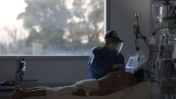 Пандемия коронавируса COVID-19. Врач в больнице в Буэнос-Айресе, Аргентина, ухаживает за пациентом на аппарате ИВЛ - Sputnik Грузия