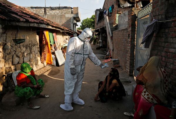 Темпы распространения коронавируса в Индии так растут, что скоро эта страна может выйти на первое место в мире по количеству зараженных. На фото - медицинские работники  проводят термоскрининг жителей бедных районов Индии - Sputnik Грузия