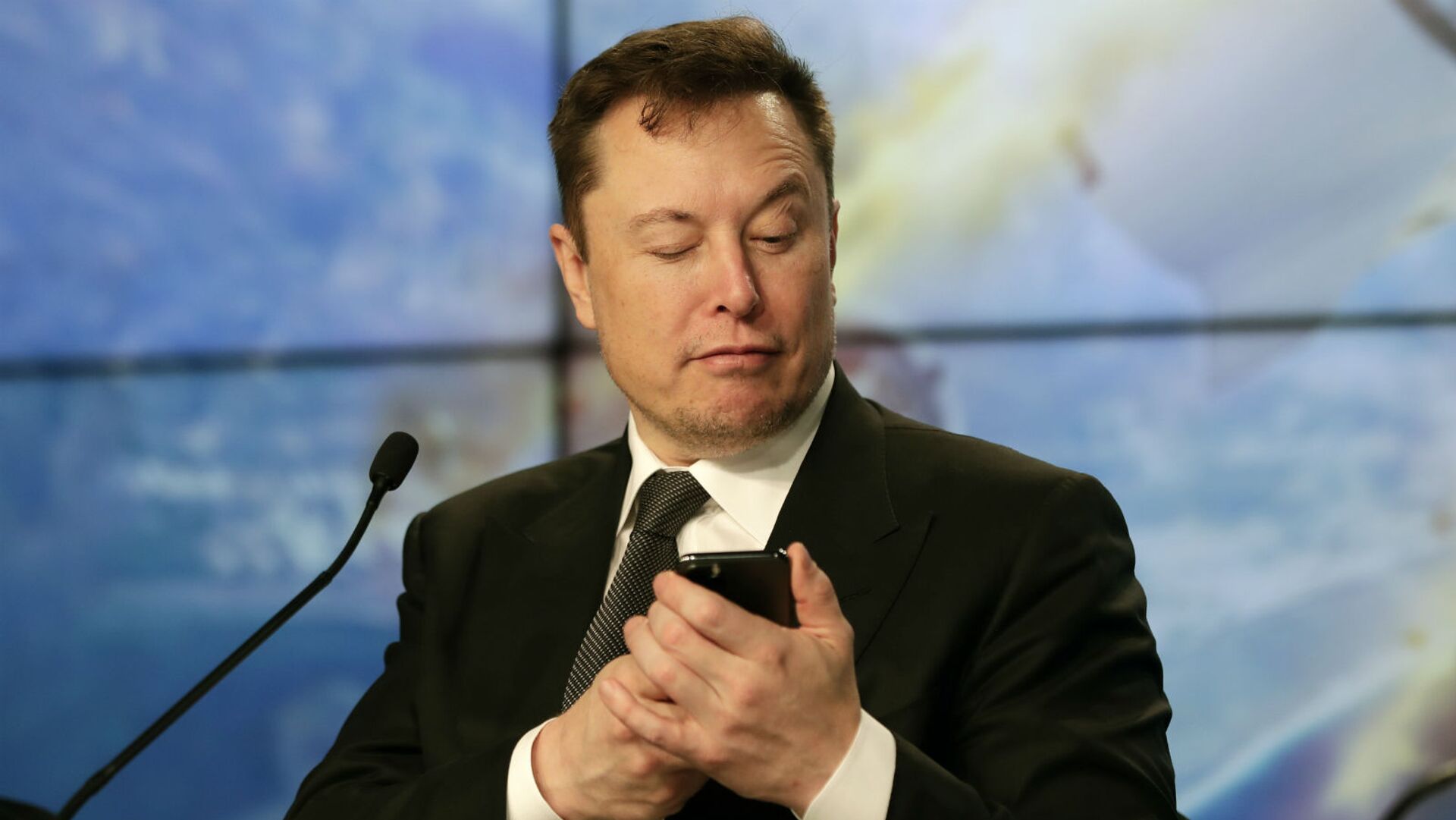 Основатель SpaceX Илон Маск шутит с журналистами, делая вид, что ищет ответ на вопрос по мобильному телефону во время пресс-конференции после испытательного полета ракеты Falcon 9 SpaceX (19 января 2020). Флорида - Sputnik Грузия, 1920, 15.04.2022