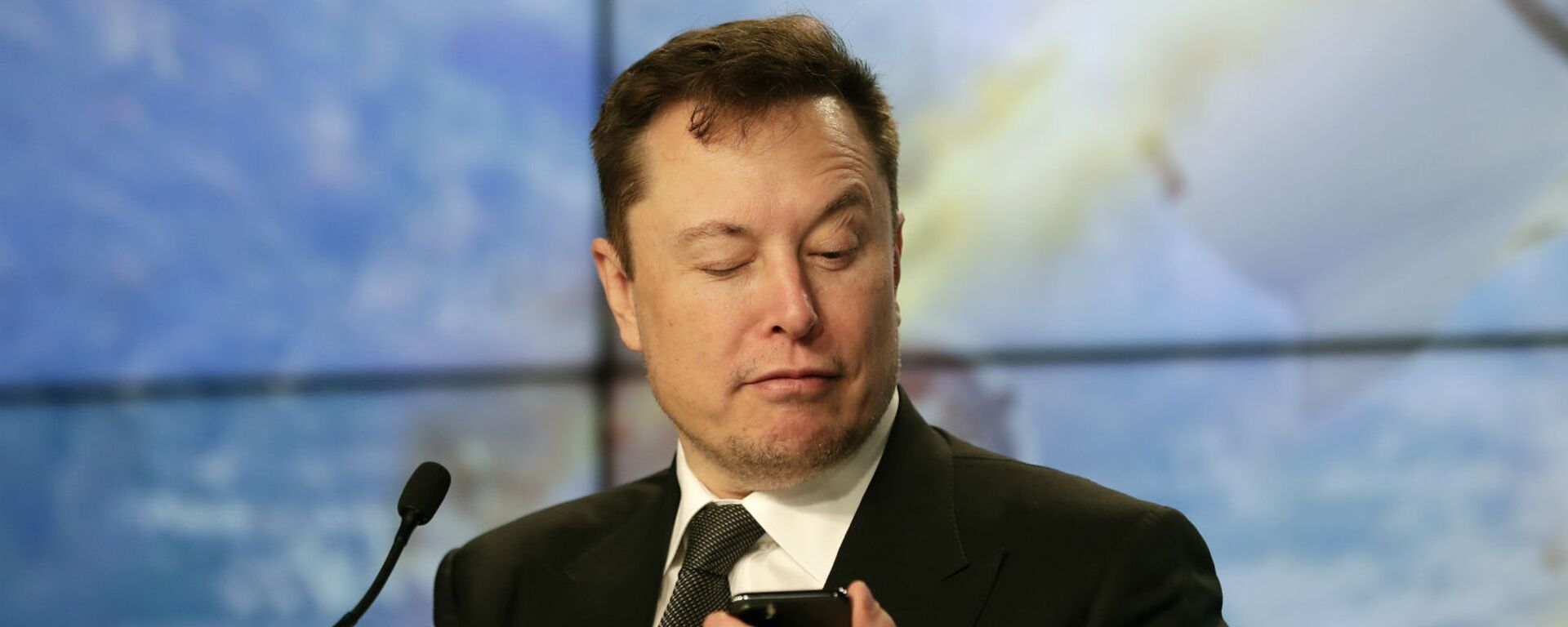 Основатель SpaceX Илон Маск шутит с журналистами, делая вид, что ищет ответ на вопрос по мобильному телефону во время пресс-конференции после испытательного полета ракеты Falcon 9 SpaceX (19 января 2020). Флорида - Sputnik Грузия, 1920, 02.12.2020
