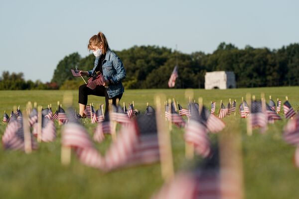 В США число погибших от коронавируса превысило 200 тысяч человек. На фото - молодая девушка в маске размещает флаги Соединенных Штатов в память о погибших от COVID-19 на Национальной аллее в Вашингтоне - Sputnik Грузия