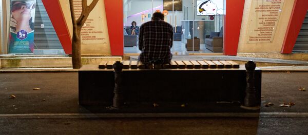 Пожилой мужчина в одиночестве сидит на скамейке на улице Пекина - Sputnik Грузия