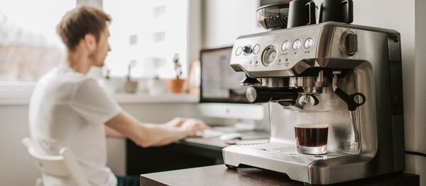 პროგრამისტი კომპიუტერისა და ყავის მადუღარის ფონზე   - Sputnik საქართველო