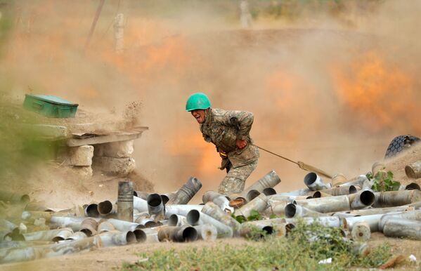 Тем временем с обеих сторон конфликта продолжает активно работать артиллерия. На фото - артиллеристы сил обороны Карабаха ведут обстрел азербайджанских позиций - Sputnik Грузия