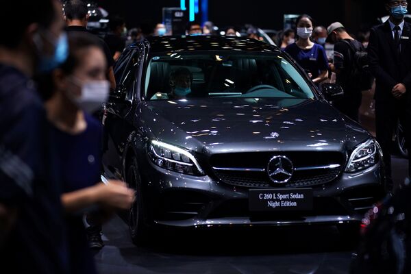 Но все равно, немецкие автомобили - это престиж, качество, комфорт и удобство. На фото - посетители осматривают новый спортивный седан Mercedes-Benz C260L night edition - Sputnik Грузия