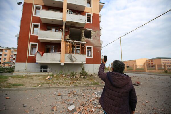 Житель азербайджанского города Тертер показывает на разрушения в жилом доме после обстрела со стороны сил обороны Нагорного Карабаха - Sputnik Грузия