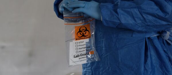 Пандемия коронавируса COVID 19 - медик держит в руках пакет с ПЦР тестами - Sputnik Грузия