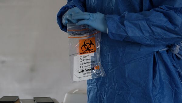 Пандемия коронавируса COVID 19 - медик держит в руках пакет с ПЦР тестами - Sputnik Грузия