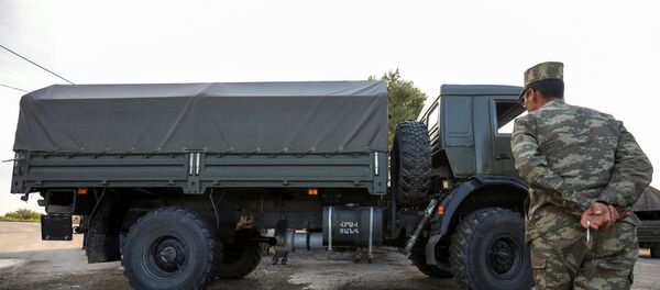 Нагорный Карабах - солдат азербайджанской армии осматривает захваченную армянскую технику - Sputnik Грузия