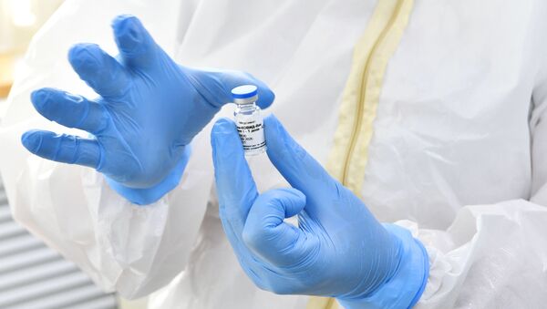 Медсестра держит в руках ампулу с вакциной от коронавирусной инфекции  - Sputnik Грузия