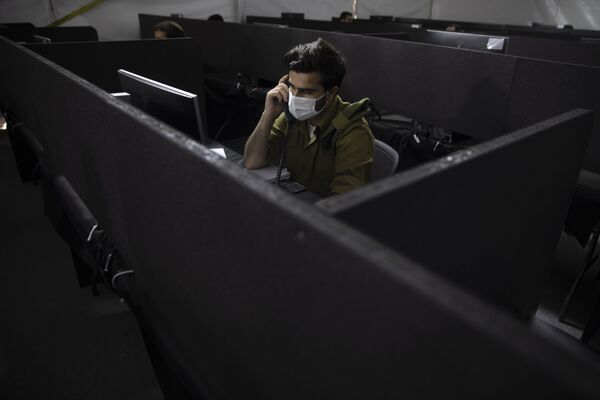 Израильские военнослужащие обзванивают граждан, у которых подтвержден коронавирус, и по телефону ведут опрос об их самочувствии. Рамле, Израиль - Sputnik Грузия
