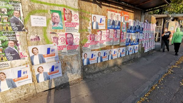 Предвыборная символика. Расклеенные по городу плакаты разных партий и блоков - Sputnik Грузия