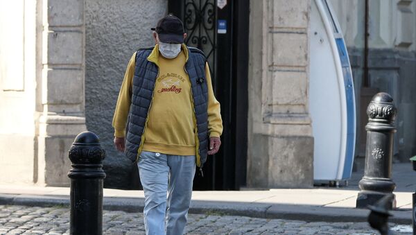 Пандемия коронавируса. Пожилой мужчина идет по улице в маске - Sputnik Грузия