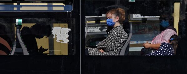 Пассажиры в автобусе в масках во время эпидемии коронавируса - Sputnik Грузия