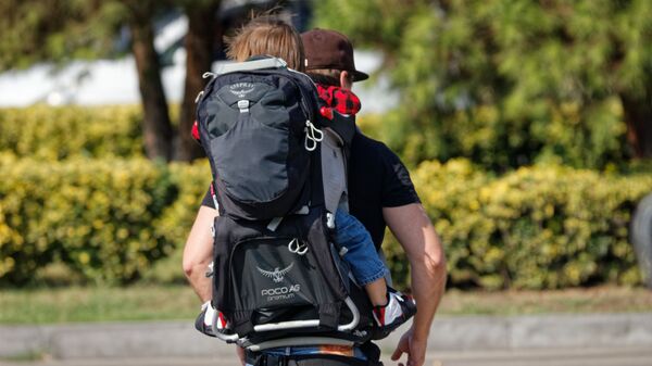 Дети и родители. Папа несет ребенка в рюкзаке за спиной во время прогулки - Sputnik Грузия