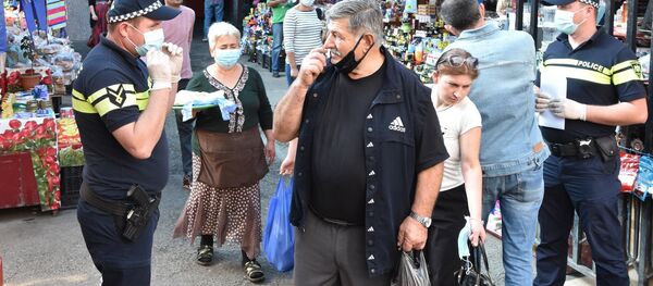 Эпидемия коронавируса. Полицейские следят за обязательным ношением масок на рынке - Sputnik Грузия