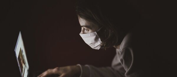 Девушка за ноутбуком в защитной маске - Sputnik Грузия