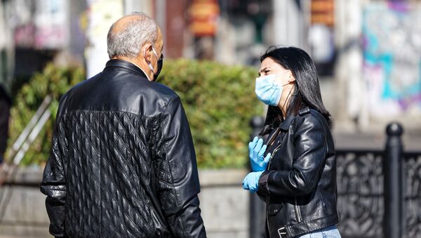Эпидемия коронавируса. Мужчина и девушка в масках на улице - Sputnik Грузия