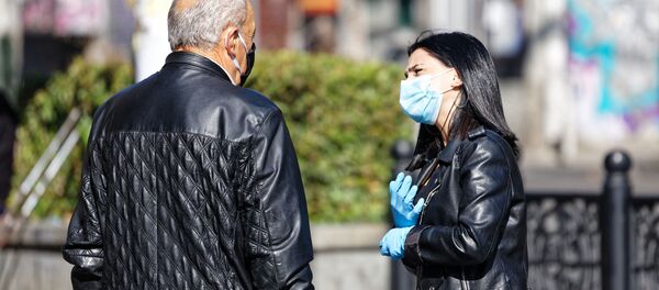 Эпидемия коронавируса. Мужчина и девушка в масках на улице - Sputnik Грузия