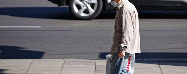 Эпидемия коронавируса. Пожилой мужчина в маске идет по улице Эпидемия коронавируса. Пожилой мужчина в маске идет по улице - Sputnik Грузия