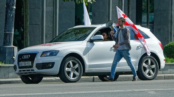 Предвыборная символика и агитация. Человек с мегафоном и машина с флагом Грузии - Sputnik Грузия
