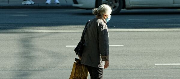 Эпидемия коронавируса. Пожилая женщина в маске идет по улице - Sputnik Грузия