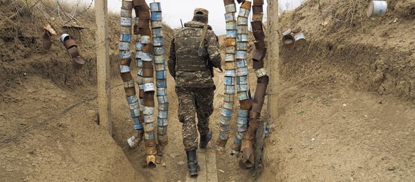 Служащий сил обороны Карабаха, этнический армянин, идет по траншее к огневой позиции. Нагорный Карабах - Sputnik Грузия