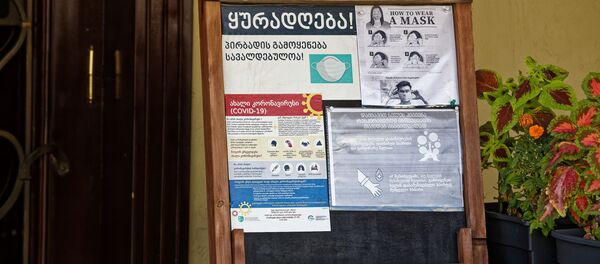Эпидемия коронавируса. На входе в ресторан баннер с информацией об обязательном ношении масок - Sputnik Грузия