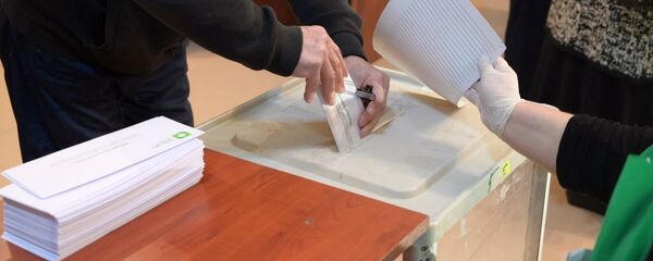 Парламентские выборы в Грузии 2020 - избиратели принимают участие в голосовании. Бюллетень опускают в урну - Sputnik Грузия