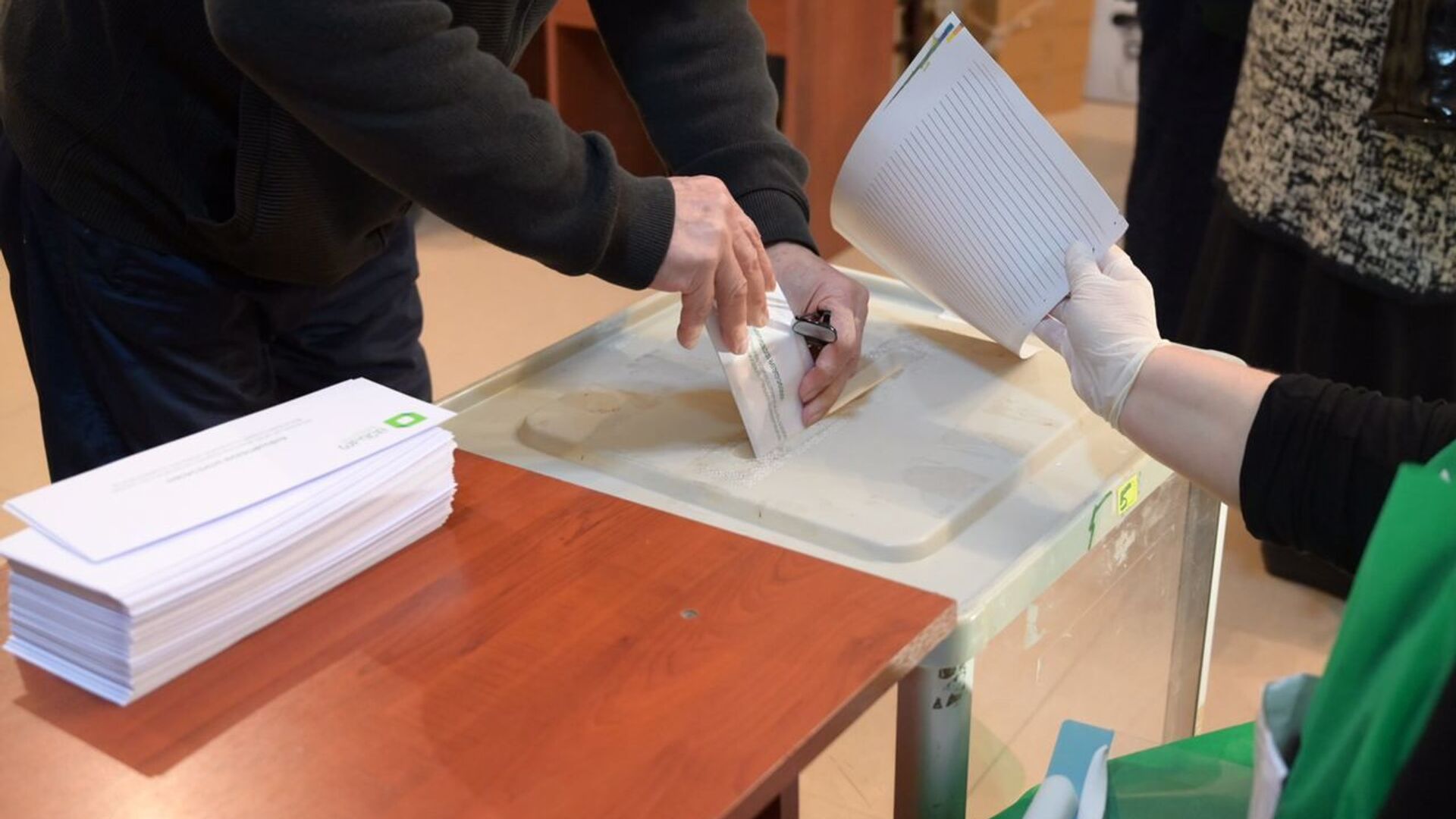 Парламентские выборы в Грузии 2020 - избиратели принимают участие в голосовании. Бюллетень опускают в урну - Sputnik Грузия, 1920, 28.08.2021