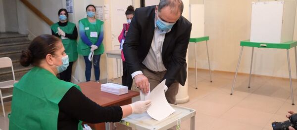 Парламентские выборы в Грузии 2020 - избиратели участвуют в голосовании. Бюллетень опускают в урну - Sputnik Грузия