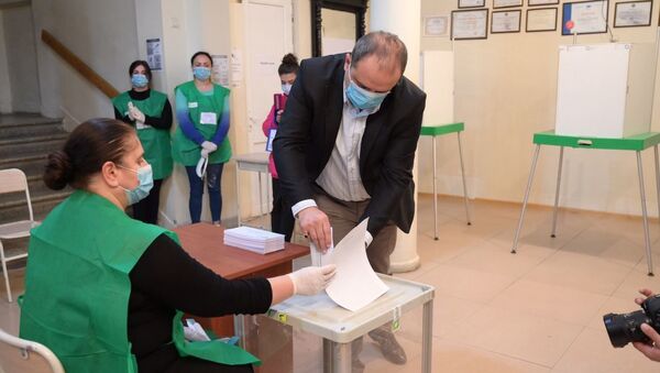Парламентские выборы в Грузии 2020 - избиратели участвуют в голосовании. Бюллетень опускают в урну - Sputnik Грузия