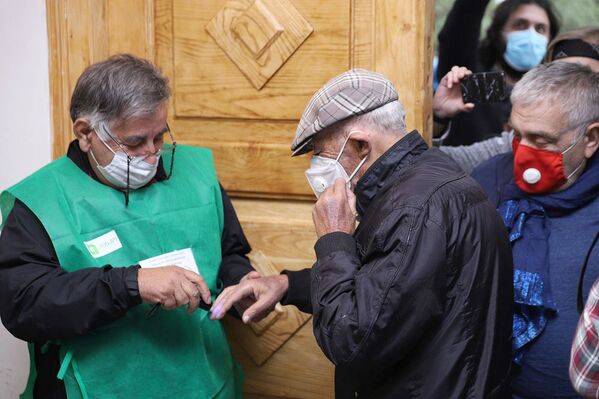 Перед входом тем, кто приходил голосовать, проверяли маркировку на пальцах рук. На фото - актер Вахтанг Кикабидзе, который значится первым номером в избирательном списке оппозиционного объединения Сила в Единстве, сформированного Единым национальным движением - Sputnik Грузия