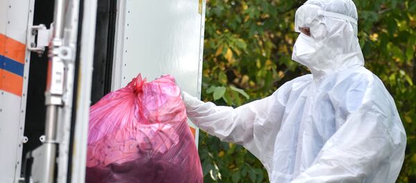 Медик складывает личные вещи больных, находящихся в госпитале для пациентов с COVID-19 - Sputnik Грузия