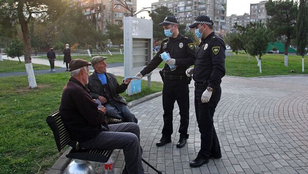 Сотрудники полиции раздают на улице маски прохожим во время эпидемии коронавируса - Sputnik Грузия