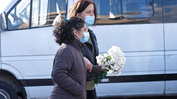 Эпидемия коронавируса. Жители столицы Грузии в масках идут с цветами по улице - Sputnik Грузия
